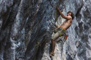 homme fort escaladant un rocher. photo