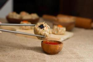 gros plan dimsum ou dim sum cuits à la vapeur chinois, sur des baguettes, cuisine traditionnelle photo