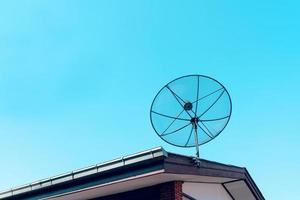 Antenne parabolique noire dans le ciel bleu photo