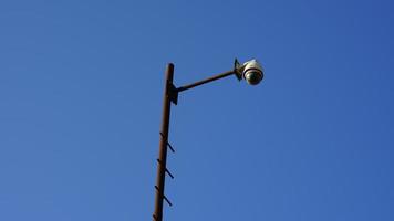 caméra accrochée à un poteau avec un ciel bleu. photo