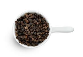 tas de poivre noir ou graines de poivre noir dans un bol en céramique isolé sur fond blanc. photo