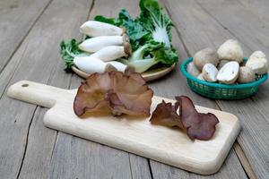 champignon noir sur une planche à découper en bois. photo