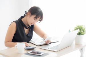 belle jeune femme asiatique calculant les dépenses du ménage et écrivant un cahier sur le bureau, fille vérifiant la facture et le stress et la note, dette d'inquiétude féminine et impôt, finance et concept d'entreprise. photo