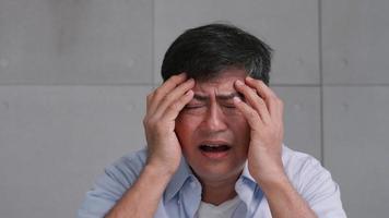 vieil homme asiatique souffrant de migraine. l'homme se sent stressé et inquiet des problèmes de santé. photo