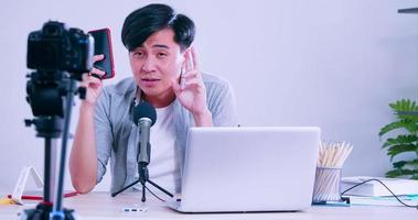 jeune homme asiatique vendant des gadgets numériques sur les réseaux sociaux en diffusant en direct depuis son domicile. photo