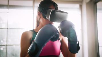 jeune femme asiatique portant des lunettes de réalité virtuelle tout en travaillant à la maison. photo