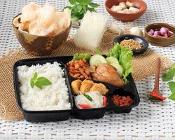 boîte de riz, nasi berkat, nasi kotak indonésien avec poulet sauce soja, oreg tempeh et pâte épicée photo