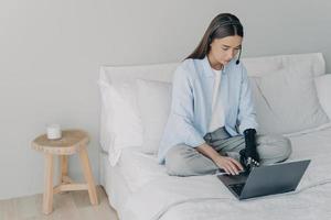 gestionnaire ou assistant à distance handicapé. une fille concentrée a une réunion en ligne à la maison. photo