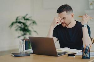 homme d'affaires frustré se sentant fatigué tout en travaillant sur son lieu de travail à la maison ou au bureau photo