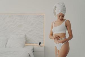 jolie jeune fille avec une figure sportive mesure sa taille avec un centimètre de ruban photo