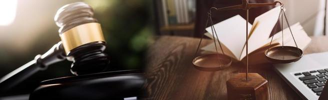 concept de justice et de droit. juge masculin dans une salle d'audience avec le marteau, travaillant avec, clavier d'ordinateur et d'accueil, lunettes, sur table à la lumière du matin photo