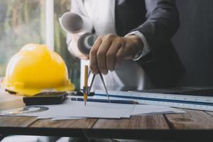 Deux collègues discutant des données de travail et tablette, ordinateur portable avec sur le projet architectural sur le chantier de construction au bureau au bureau photo