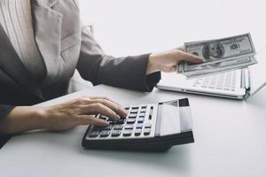 concept de comptabilité d'entreprise, homme d'affaires utilisant une calculatrice avec ordinateur portable, budget et papier de prêt au bureau. photo