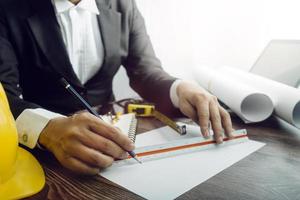 Deux collègues discutant des données de travail et tablette, ordinateur portable avec sur le projet architectural sur le chantier de construction au bureau au bureau photo