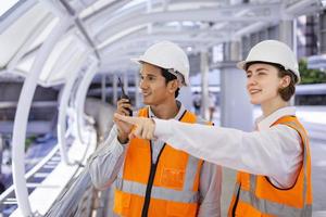 l'équipe d'ingénieurs en diversité utilise un talkie-walkie lors de l'inspection du projet de construction pour l'architecture moderne et le concept de développement immobilier photo