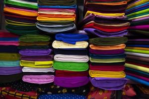 Variété artistique couleurs tons ombre tissus textiles empilés sur l'étagère du magasin de détail à vendre photo