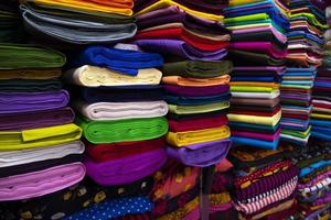 Variété artistique couleurs tons ombre tissus textiles empilés sur l'étagère du magasin de détail à vendre photo