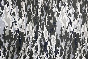 tissu avec une texture de camouflage pixélisé militaire ukrainien. tissu avec motif camouflage en formes de pixels gris, marron et vert. uniforme officiel des soldats ukrainiens photo