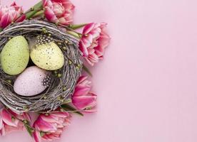 carte de voeux de printemps. oeufs de pâques dans le nid. tulipes de fleurs de printemps. photo