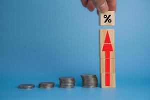 investissements en finance d'entreprise économie pile inflation des pièces et flèche rouge avec cube de bois sur le bureau. photo