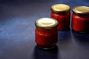 sauce tomate piquante maison adjika en bocaux. tomates, piment, ail et herbes