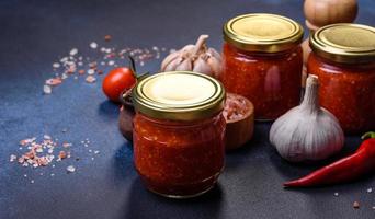 sauce tomate piquante maison adjika en bocaux. tomates, piment, ail et herbes