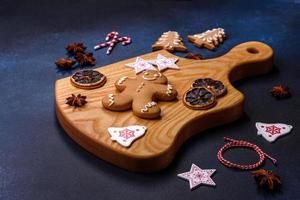éléments de décorations de noël, de bonbons et de pain d'épice sur une planche à découper en bois photo