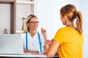 nutritionniste féminine donnant des consultations au patient. faire un plan de régime. jeune femme visitant une nutritionniste dans une clinique de perte de poids photo