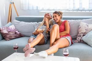 portrait d'une copine heureuse mangeant du pop-corn et regardant la télévision à la maison. soirée entre filles, divertissement et concept de malbouffe photo