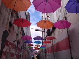 un couloir muré décoré de parapluies colorés. cette photo peut être utilisée pour tout ce qui concerne le tourisme, la ville, la vie urbaine, l'art, l'architecture