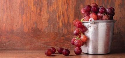 raisins rouges frais dans un petit seau en acier inoxydable pour préparer la vinification. photo