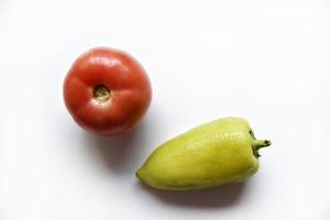 poivron vert et tomate rouge sur fond blanc. gros plan de légumes. photo