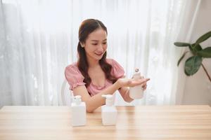 belle femme asiatique utilisant un désinfectant pour les mains lors de l'introduction de produits. photo