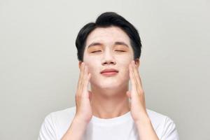 jeune homme avec un masque d'argile sur le visage photo