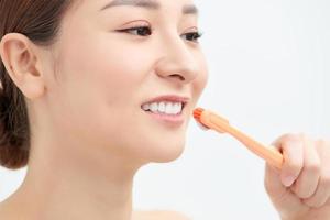 portrait en studio d'une belle jeune femme tenant une brosse à dents avec du dentifrice dessus photo