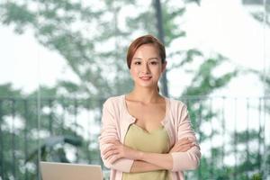 femme chef d'entreprise confiante et souriante debout les bras croisés dans un espace de bureau moderne regardant la caméra photo