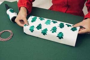 cadeaux de noël et boîtes à emballer. décorations de noël, papier d'emballage, branches d'arbres. photo