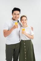 un jeune couple boit du jus d'orange sur fond blanc photo