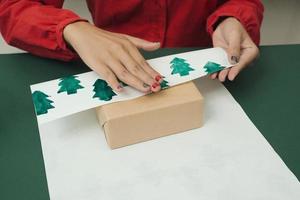 cadeaux de noël et boîtes à emballer. décorations de noël, papier d'emballage, branches d'arbres. photo