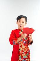 petit garçon vietnamien tenant des enveloppes rouges pour le tet. le mot signifie double bonheur. c'est le cadeau du nouvel an lunaire ou des vacances du tet sur fond isolé photo