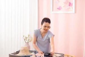 jeune femme valise d'emballage sur le lit, gros plan photo