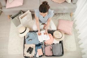 main de femme emballant un bagage pour un nouveau voyage et voyageant pour un long week-end photo