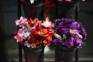 les fleurs sont vendues dans la rue. fleurs artificielles pour cimetière. détails du fleuriste. fleurs en plastique. photo