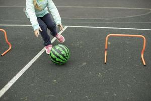 relais pour les enfants. jeu de sport. les enfants roulent de la viande autour de l'aire de jeux. amusant en été. photo