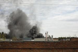 feu dans la rue. fumée noire contre le ciel. allumage dans le bloc de garage. photo