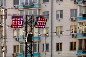 éclairage public avec spots rouges et roses sur le fond d'un immeuble d'appartements en flou. photo