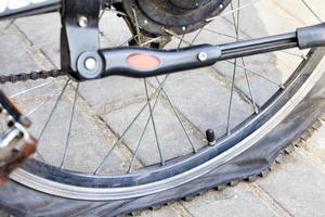 une roue de bicyclette crevée sur le fond des dalles de pavage. fermer. photo