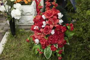 fleurs sur la tombe du soldat. couronne de deuil. fleurs artificielles rouges. photo