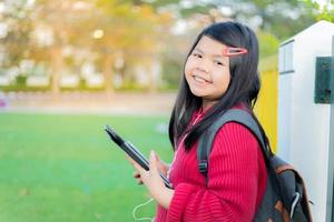 fille asiatique regardant une table sur la pelouse de l'école photo