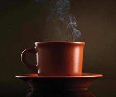 tasse de café avec de la fumée sur fond sombre photo